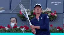 a woman is holding a tennis racquet in her hand while playing tennis .