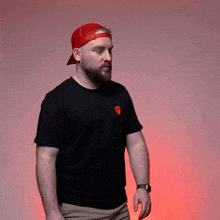 a man wearing a red baseball cap and a black shirt