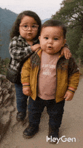 a boy wearing an awesome like mom shirt is standing next to a little girl