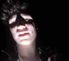 a close up of a person 's face with a light shining on it .