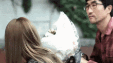 a man is giving a woman a bouquet of flowers .