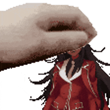 a hand is holding a doll in a red coat