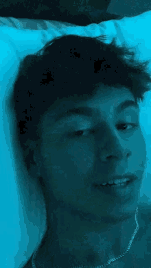 a man is laying on a bed with a blue light behind him .