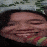 a close up of a woman 's face with her eyes closed smiling