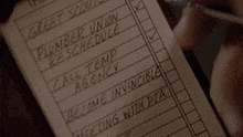a person is holding a notepad with a list of things to do