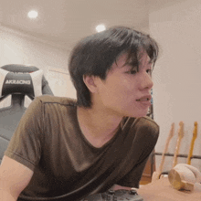 a man sitting at a table with a akracing chair in the background