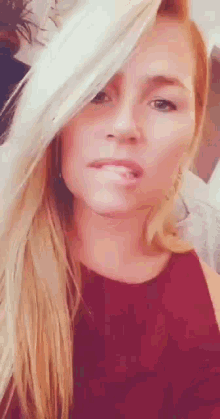 a woman with blonde hair is making a funny face with her tongue out .