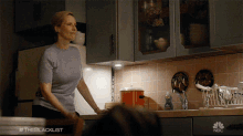 a woman standing in a kitchen with a nbc logo on the bottom