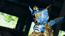 a person in a blue and gold costume with a mask on
