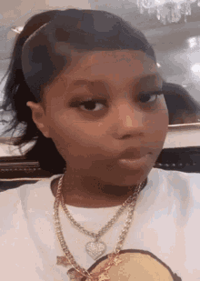 a girl wearing a white shirt and a gold chain necklace