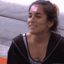 a woman has a pink sticky note on her forehead