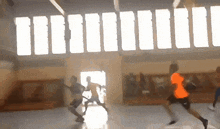 a group of people are playing basketball in a gymnasium