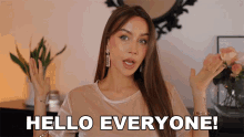 a woman says hello everyone with her hands up