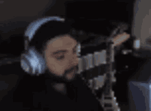 a man wearing headphones is singing into a microphone while playing a guitar .