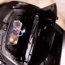 a black car with the trunk open and a bag of food in the back