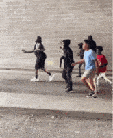a group of young men are walking down a sidewalk