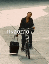a woman is riding a bike with a suitcase behind her and the words " надоело " on the bottom right