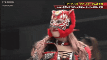 a woman wearing a red mask is on a stardom wrestling show