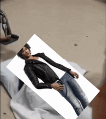 a picture of a man laying on a bed with a chain around his neck