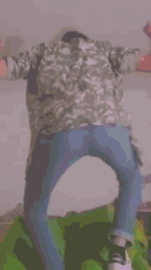 a person in a pink shirt and blue jeans is standing on a bed with their arms outstretched