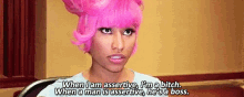 a woman with pink hair is sitting in a chair and talking about being assertive