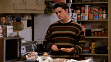 a man in a striped sweater is holding a piece of bread in his hand