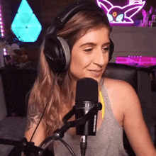 a woman wearing headphones and a microphone is smiling .