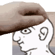 a hand is putting a piece of wood on a white man 's head .