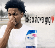 a man holds his nose in front of a bottle of head & shoulders