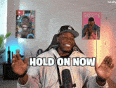 a man with his arms outstretched and the words hold on now on his chest