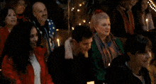 a woman in a red jacket is dancing in front of a crowd of people