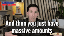 a man says " and then you just have massive amounts " in front of a bookcase