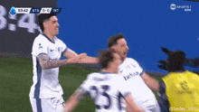 a group of soccer players are celebrating a goal during a match