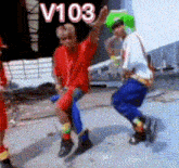 a group of people are dancing with the word v103 above them