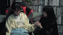 a woman sits in a chair that says akracing on the back