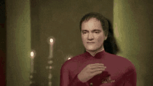 a man in a red suit is clapping his hands in front of a woman
