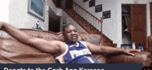 a man in a purple phoenix jersey sits on a couch with his arms outstretched