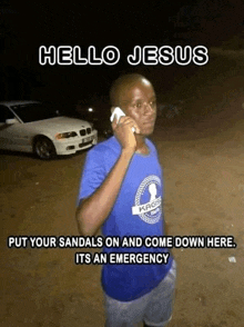 a man in a blue shirt talking on a cell phone with the words hello jesus put your sandals on and come down here its an emergency