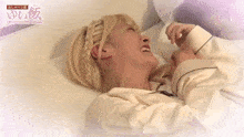 a woman with blonde hair is laying on a bed with chinese writing on it