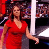 a woman in a red dress is walking on a stage .