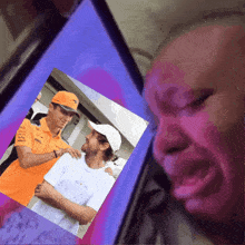 a man 's face is visible behind a picture of two men wearing dell shirts