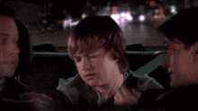 a young boy wearing headphones is sitting in a car