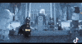 a lego batman is standing in front of a podium surrounded by other lego figures .