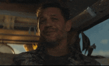 a man with a beard wearing a hawaiian shirt smiles for the camera