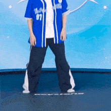 a man wearing a blue jersey with the number 87 on it is standing on a trampoline .