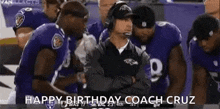 a group of football players are standing around a coach wearing headphones .