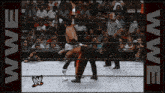 two wrestlers in a wrestling ring with the word wwe on the bottom right