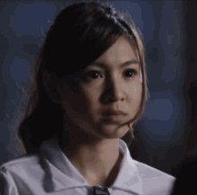 a girl with a headband on her head looks at the camera with a serious look on her face
