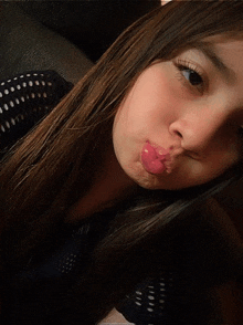 a girl with long hair is making a funny face with her tongue out