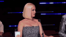 a woman is speaking into a microphone on a stage .